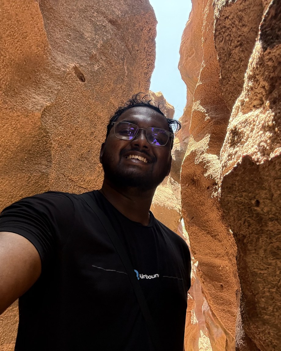 Arun smiling in a narrow red-rock canyon